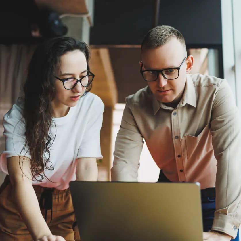 Hero image of two people working in front of a laptop